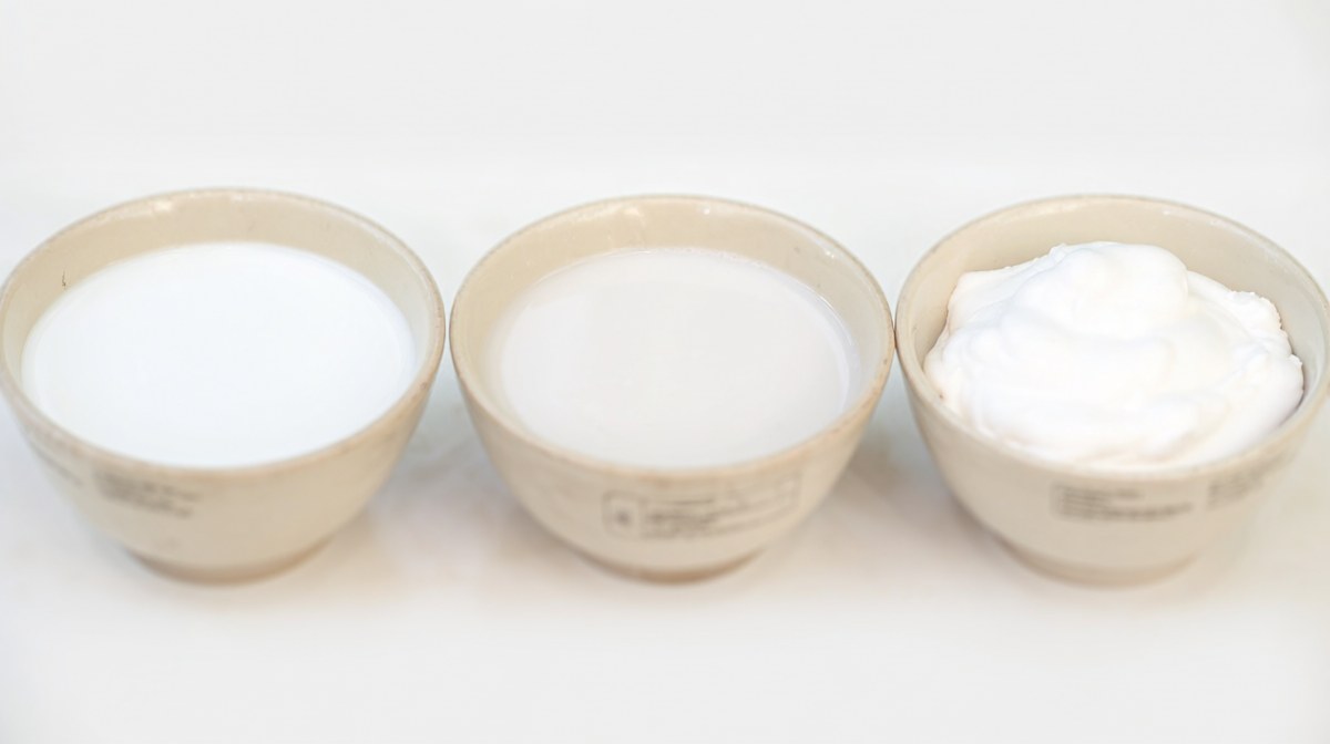 Three bowls side by side showing full fat coconut milk, light coconut milk and thicker coconut cream