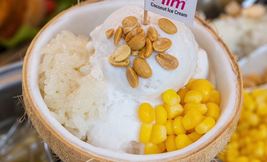 Thai coconut ice cream i-tim kati served in a coconut shell with toppings