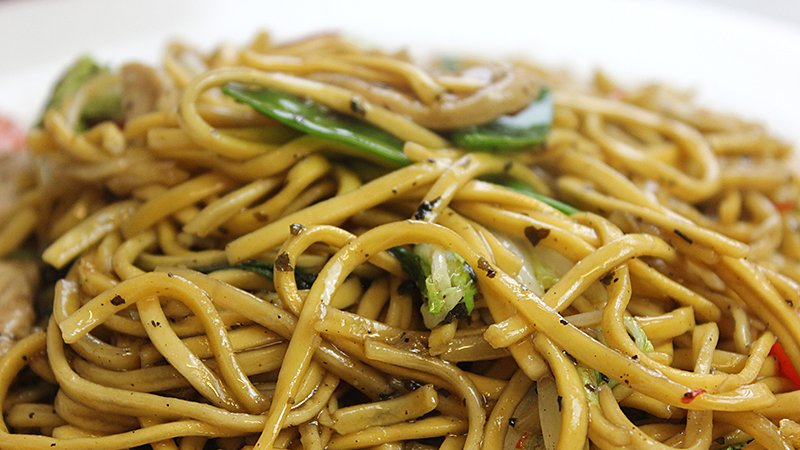 Thai drunken noodles stir fried with chicken and fresh vegetables