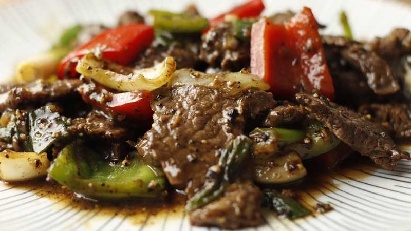 Thai black pepper beef stir fry with vegetables in a wok